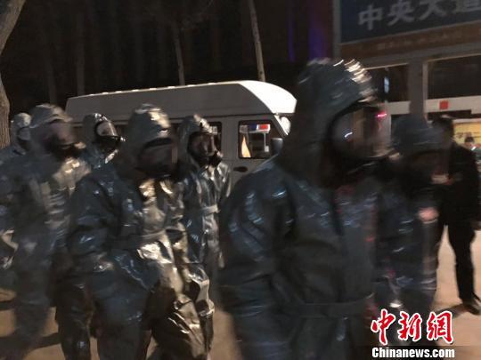 十几名身着防护服的人员头戴面具进入事发地。　胡健 摄